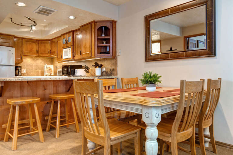 Rustic wood table, chairs, and bar stools create a cozy ambiance.
