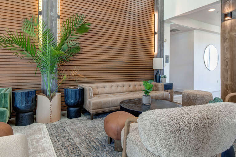 Step into a stylish lounge where warm wood tones and plush seating invite you to relax. Lush greenery and thoughtful decor create a welcoming retreat after your day of exploring.