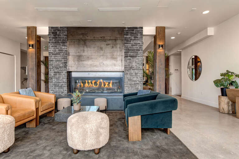 Unwind in this stylish lounge where industrial charm meets modern comfort. The inviting fireplace and plush seating create the perfect spot for your evening relaxation.