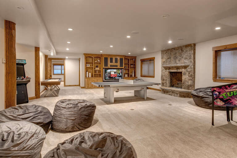 "Cozy space with table tennis, fireplace, and arcade games."
