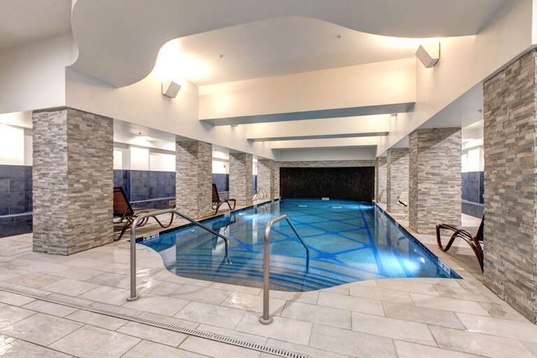 You'll love unwinding in this beautiful indoor pool, featuring elegant stone pillars, ambient lighting, and inviting loungers perfect for your next relaxing escape.
