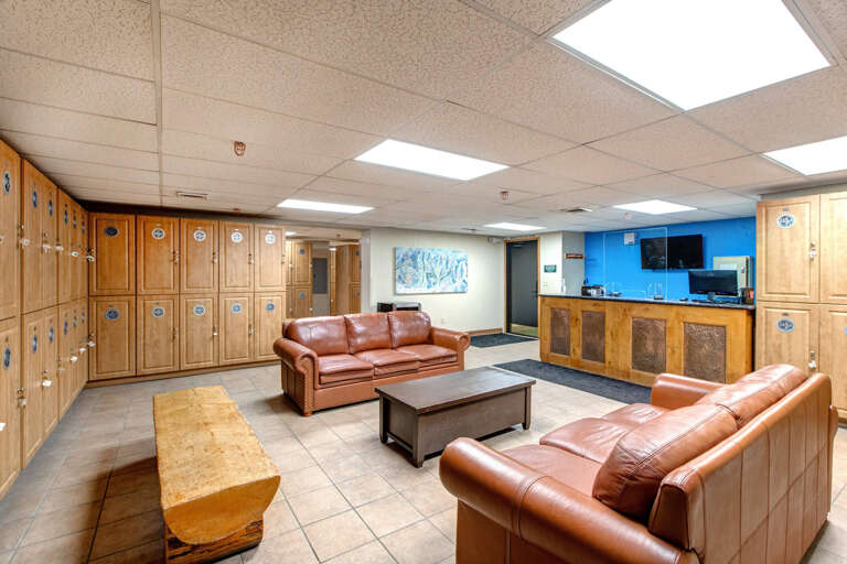 Settle into this comfortable lounge area with leather seating, personal storage lockers, and a convenient kitchenette—perfect for relaxing between your mountain adventures.