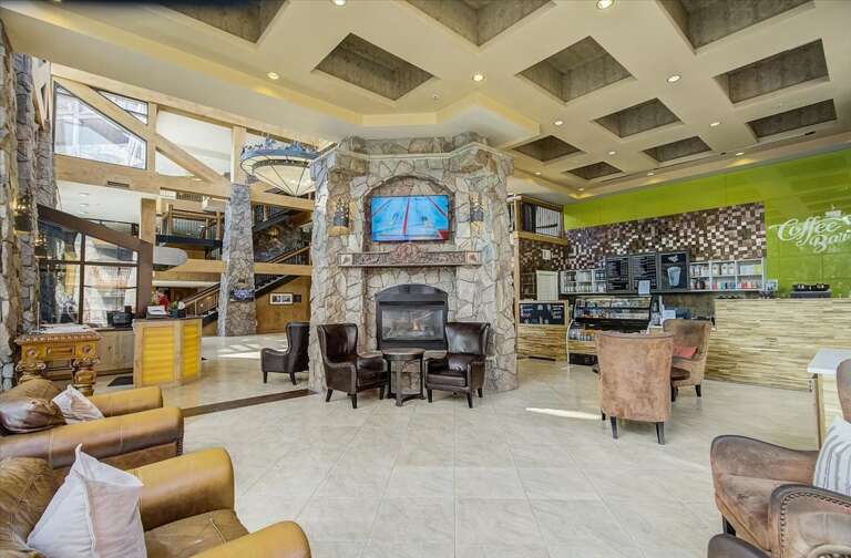 An elegant lobby welcomes you with a stunning stone fireplace, cozy seating, and a bright café bar—the perfect place to unwind after a day of adventure.