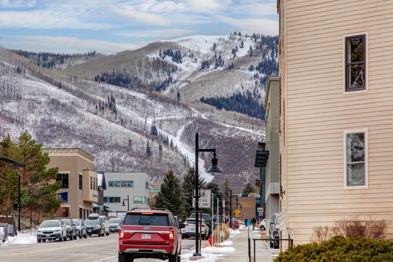 A charming mountain town setting with stunning snow-covered peaks rising above the property, offering a quintessential winter escape in a welcoming community.