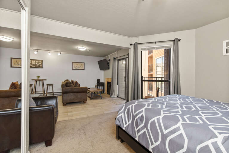 Cozy studio with queen bed, balcony, and comfy sofa chair. Cozy studio with queen bed, balcony, and comfy sofa chair.