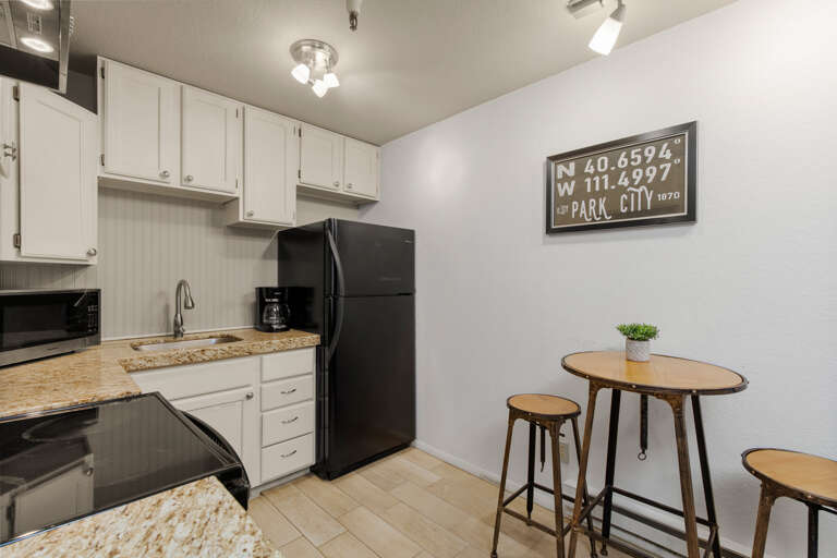 Modern amenities including electric range and sleek bar table setup. Modern amenities including electric range and sleek bar table setup.