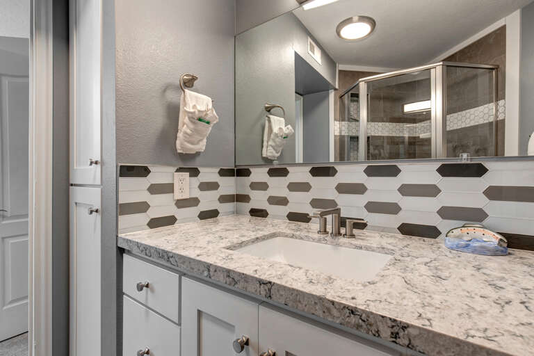 Reflective sink area with a sleek mirror, perfect for morning routines.