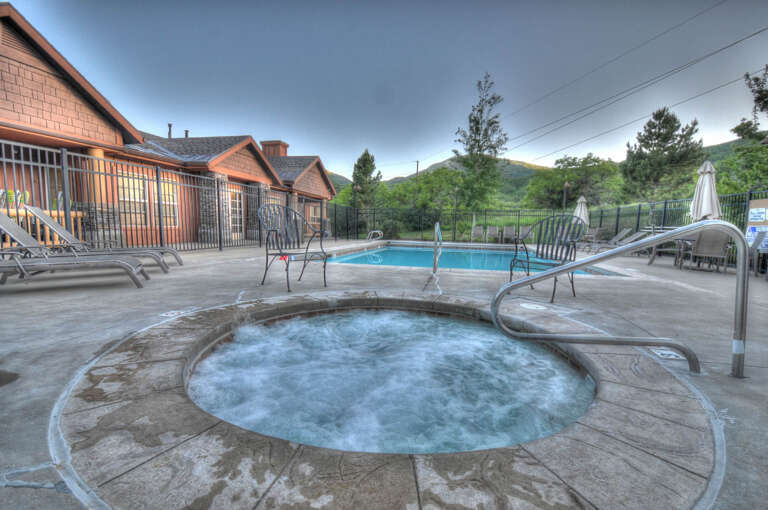 A bubbling hot tub and refreshing pool await, surrounded by mountain views and comfortable loungers—your perfect spot to unwind after exploring nearby trails.