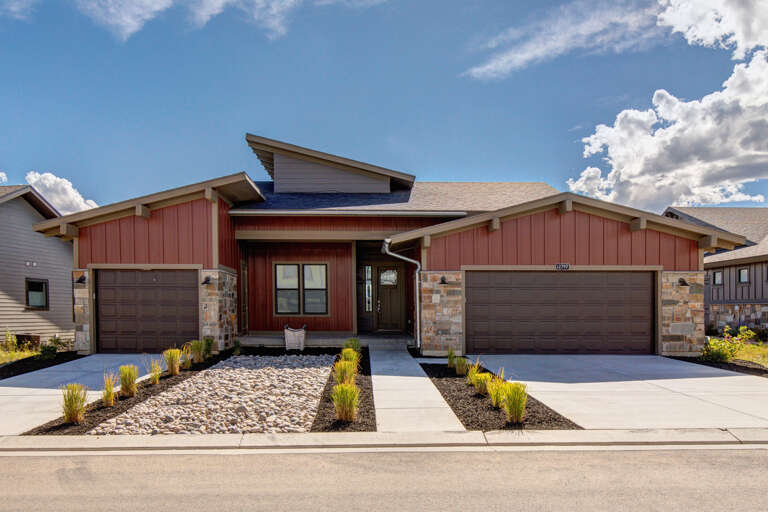 Modern mountain retreat with dramatic design and stone accents, situated in a peaceful neighborhood beneath stunning skies.