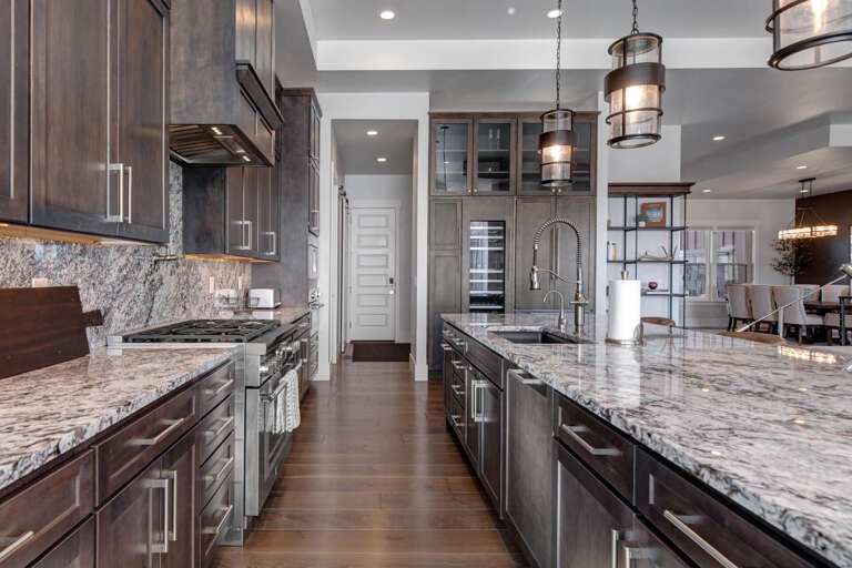You'll love cooking in this gourmet kitchen with its sleek granite counters, professional-grade appliances, and inviting industrial-style lighting that makes meal prep feel effortless.
