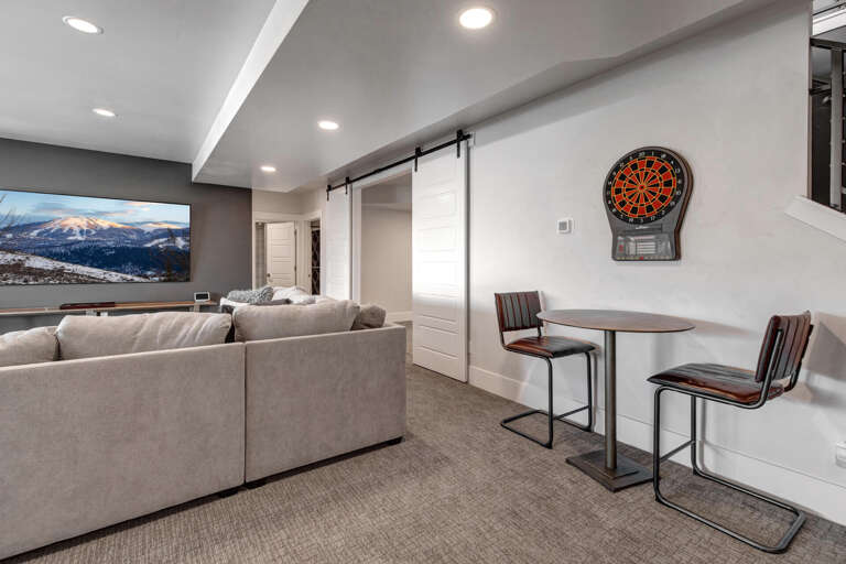 Your entertainment retreat awaits with a dartboard for friendly competition, cozy seating for movie nights, and a sleek bar table perfect for casual drinks and conversation.