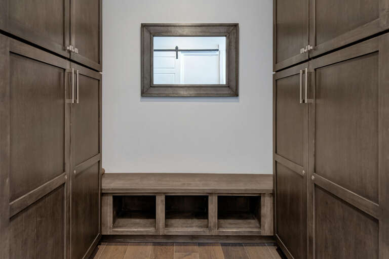 Your entryway welcomes you with warm wood cabinetry and thoughtful storage cubbies—perfect for keeping your essentials organized while maintaining a polished, inviting space.