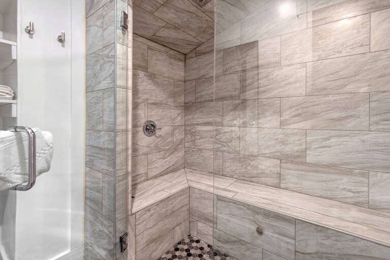 Step into this spa-like shower featuring gorgeous wood-look tile, a spacious walk-in design, and modern fixtures that invite relaxation after a day of adventure.