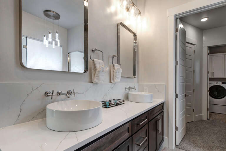 Unwind in your private spa-like bathroom with modern dual vessel sinks, elegant marble countertops, and sophisticated finishes that invite relaxation after a day of exploring.