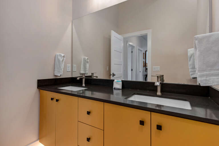 Reflective sink area with a sleek mirror, perfect for morning routines. Reflective sink area with a sleek mirror, perfect for morning routines.