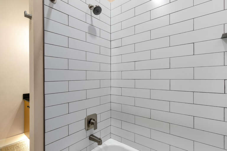 Step into your private sanctuary with a crisp, modern shower featuring subway tile walls and a glass enclosure—your refreshing escape awaits.