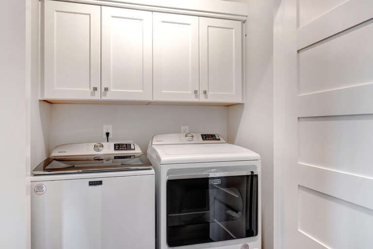You'll love the in-unit washer and dryer with cabinet storage above, making laundry day easy and keeping everything organized in this bright, clean space.