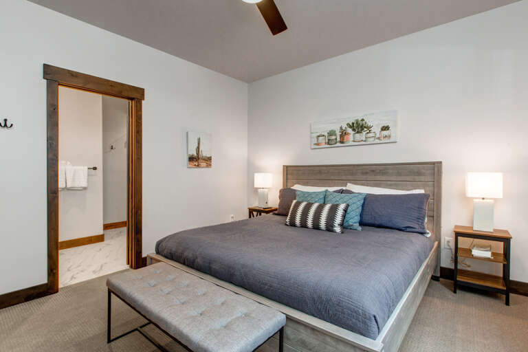 This cozy bedroom features a plush bed, warm lighting, and rustic touches, offering a peaceful retreat where you can unwind after exploring the area.