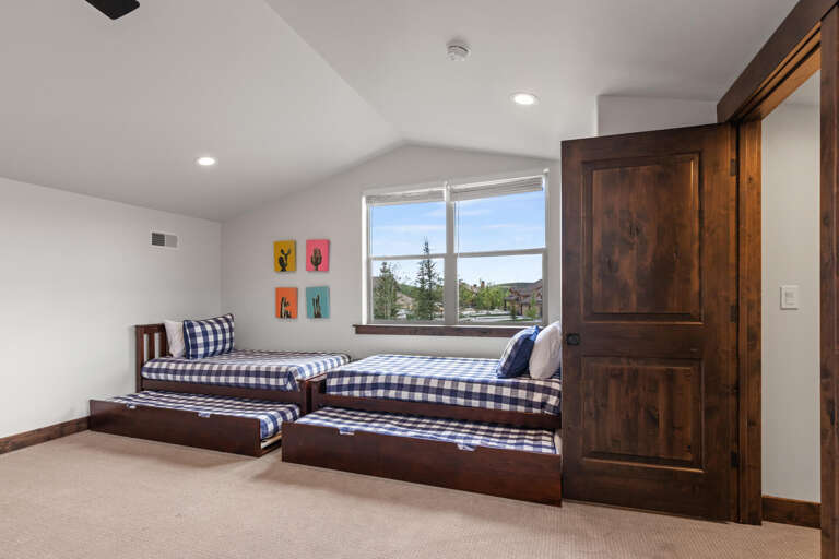 Rest easy in this cozy bedroom with twin beds and a trundle, perfect for kids or friends. Enjoy views of the surrounding area while you unwind in comfort.