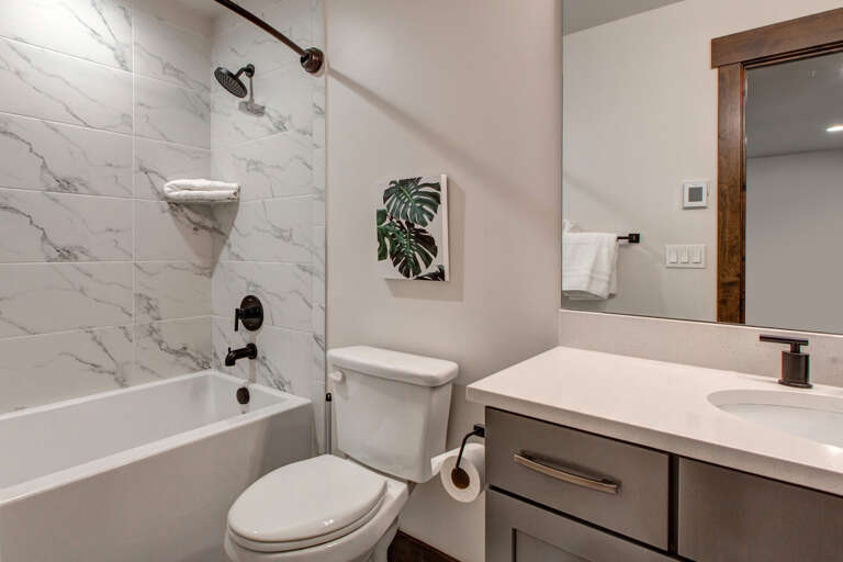 Slip into this sparkling marble-tiled shower after your adventures, or soak in the tub with fresh towels at the ready. Your modern retreat awaits with clean lines and calming comfort.