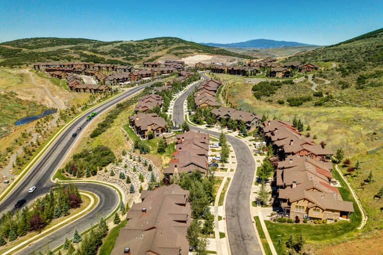 This upscale mountain community sits nestled in rolling hills with convenient road access, surrounded by natural landscape and distant mountain views.