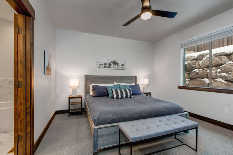 Unwind in your serene bedroom with a plush king bed, modern furnishings, and a window framing stunning desert rock formations—your peaceful retreat awaits.