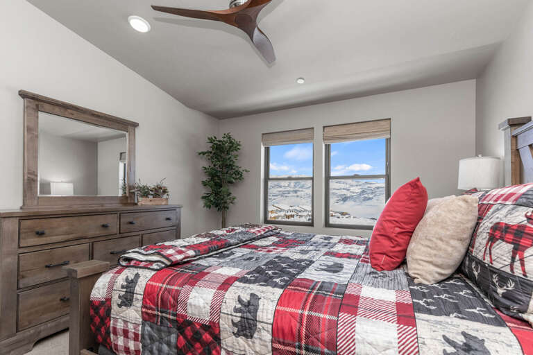 Wake up to stunning mountain views framed by your windows. This cozy bedroom blends rustic wood furnishings with modern comfort, creating your perfect retreat after a day of adventure.