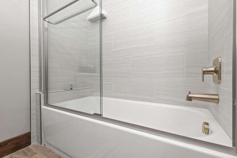 Slip into your private soaking tub or rinse off in the enclosed shower—this modern bathroom offers clean lines and a spa-like feel for ultimate relaxation.