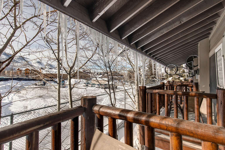 Step onto your private balcony and take in the crisp mountain views. Wooden railings frame the snowy landscape and ski village below—your cozy alpine retreat awaits.