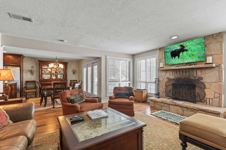 Cozy ambiance with a wood burning fireplace, comfy sofa set, and TV.