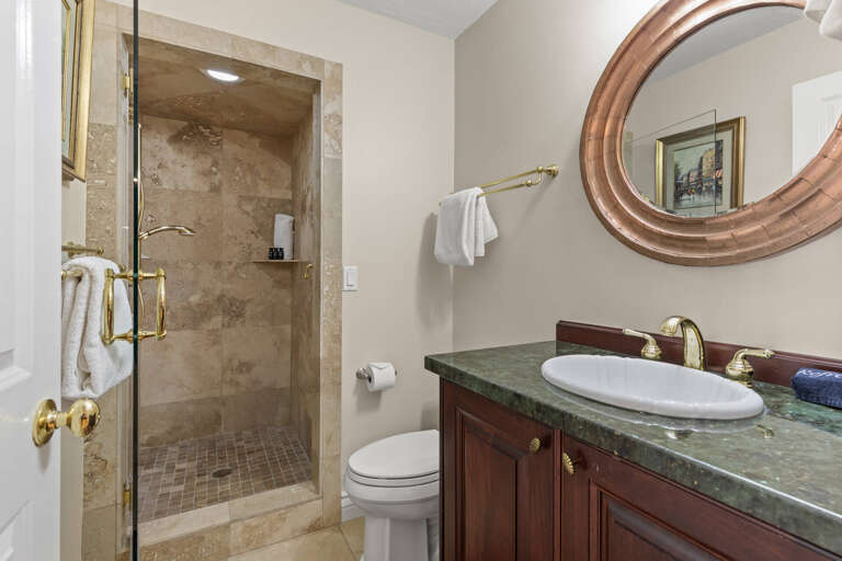 Elegant sink, mirror, toilet, and shower in modern design.