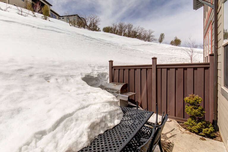Private patio with a grill, perfect for outdoor winter dining surrounded by snowy slopes and mountain views.