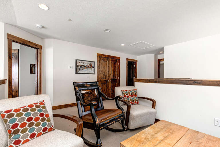 Settle into your private upstairs lounge, where rustic wood accents and cozy seating create the perfect retreat for unwinding after a day of mountain adventures.