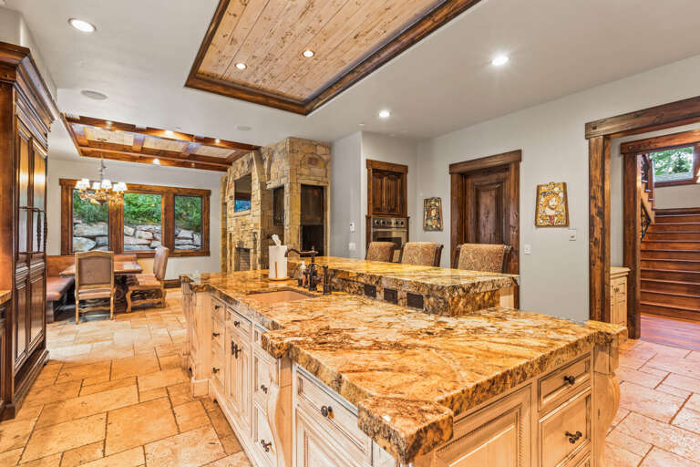 Your gourmet kitchen welcomes you with a massive granite island perfect for meal prep and gathering, while the rustic stone fireplace adds warmth to your mountain retreat.