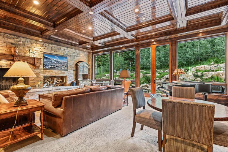Sink into plush leather seating and soak in the warmth of the stone fireplace while gazing out at your private mountain retreat through floor-to-ceiling windows.