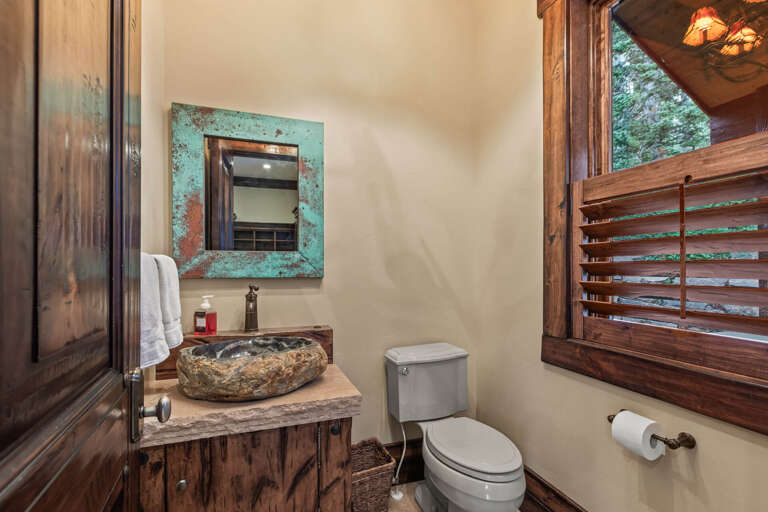 Step into your private bathroom where rustic charm meets modern comfort. Natural stone sink, weathered wood vanity, and turquoise accents create a unique retreat for refreshing after adventures.