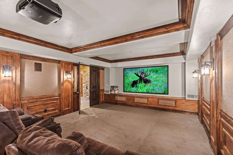 Your private home theater awaits with plush recliners, a massive screen, and rich wood details—perfect for movie nights in absolute comfort.