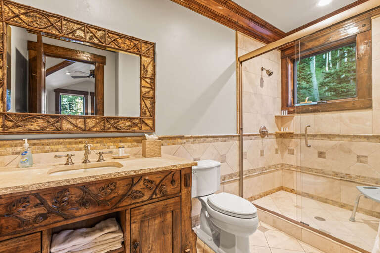 Unwind in this beautifully designed bathroom featuring elegant tile work, a spacious walk-in shower, and rich wood accents that add warmth and character to your daily routine.