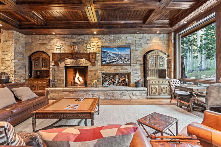 Unwind in your elegant living room, where a crackling stone fireplace and rich wood beam ceiling create a cozy mountain retreat you'll never want to leave.