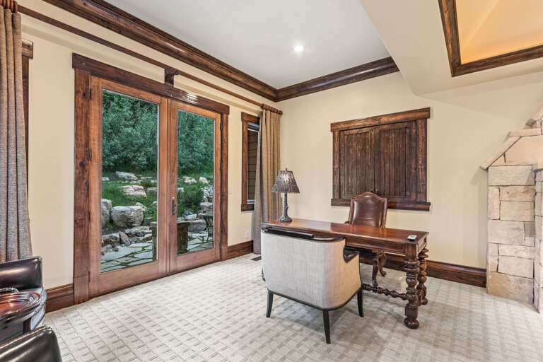 Your private workspace blends rustic charm with modern comfort. Rich wood beams frame garden views through glass doors, while elegant furnishings invite focus and relaxation.