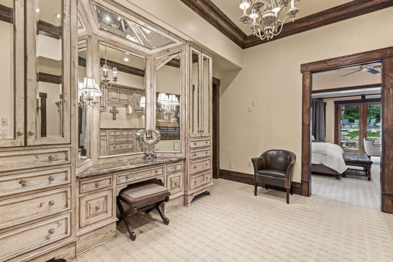 Your private dressing room features stunning vintage-inspired cabinetry with elegant lighting, ample storage, and a vanity area—your personal retreat for getting ready in comfort and style.