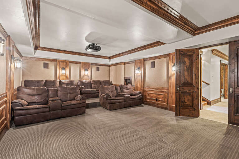 Your private screening room awaits with plush recliners and elegant wood detailing, perfect for movie nights and cozy evenings in.