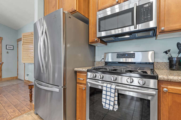 Bear Hollow Lodge 1401: The premier appliance suite includes a spacious stainless refrigerator, a high-end Samsung gas range, a microwave, and a dishwasher.