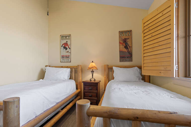 Relax in your cozy ski-themed bedroom with two comfortable twin beds, rustic log furnishings, and vintage ski posters that capture the mountain spirit you'll enjoy throughout your stay.