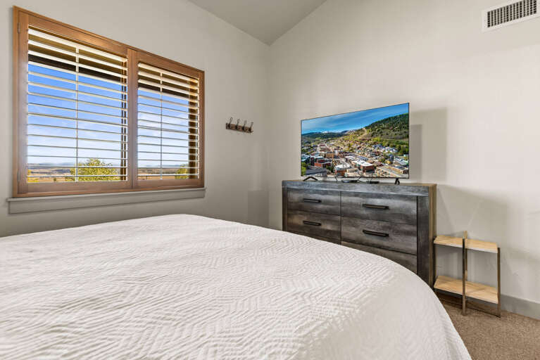 Wake up to serene views through shuttered windows and unwind in your tranquil bedroom retreat, complete with modern furnishings and a TV for your comfort.