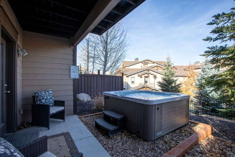 Soak in the bubbling hot tub on this private terrace, framed by mountain views and evergreens—an ideal spot to unwind after exploring nearby trails and alpine adventures.