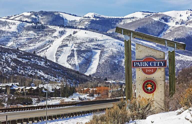 Park City's historic mountain backdrop features pristine ski slopes and forested ridges, with this welcome marker greeting travelers at the entrance to the resort town.