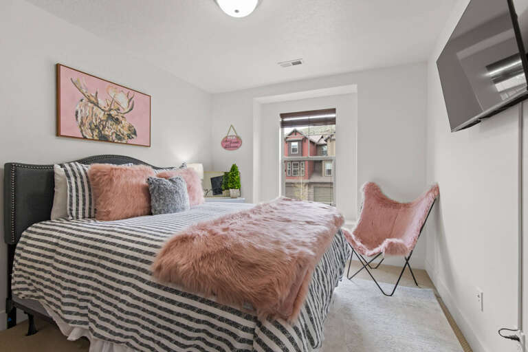 Your cozy retreat awaits with plush bedding, charming artwork, and a peaceful neighborhood view—perfect for unwinding after exploring the city.