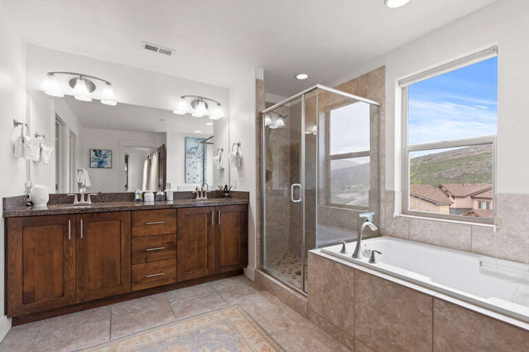 Unwind in your spacious bathroom, featuring double vanities, a separate shower, and a soaking tub with mountain views that invite relaxation.