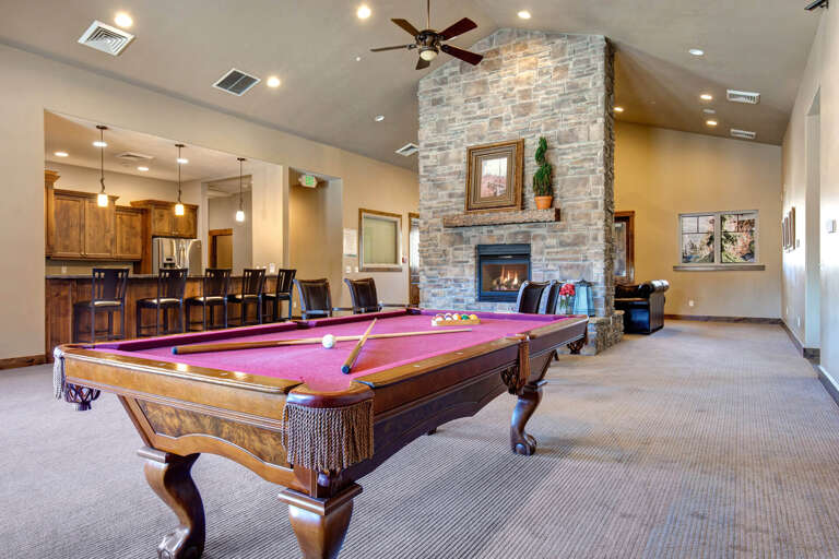 Gather around a billiard table in a spacious lounge with a cozy stone fireplace, high ceilings, and stylish seating—perfect for unwinding after your day's adventures.